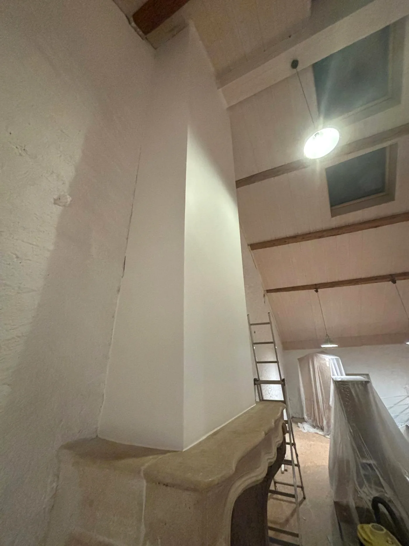 Cheminée après travaux : habillage enduit et peint, finition blanche nette.