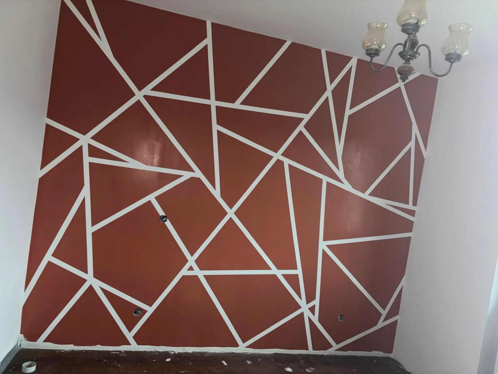 Mur d'accent terracotta à motifs géométriques tracés au ruban, peint par DOD Peinture.
