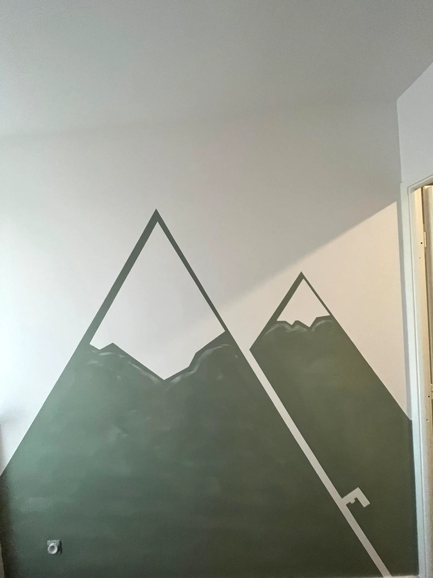 Fresque de montagnes peinte à la main dans une chambre d'enfant par DOD Peinture.