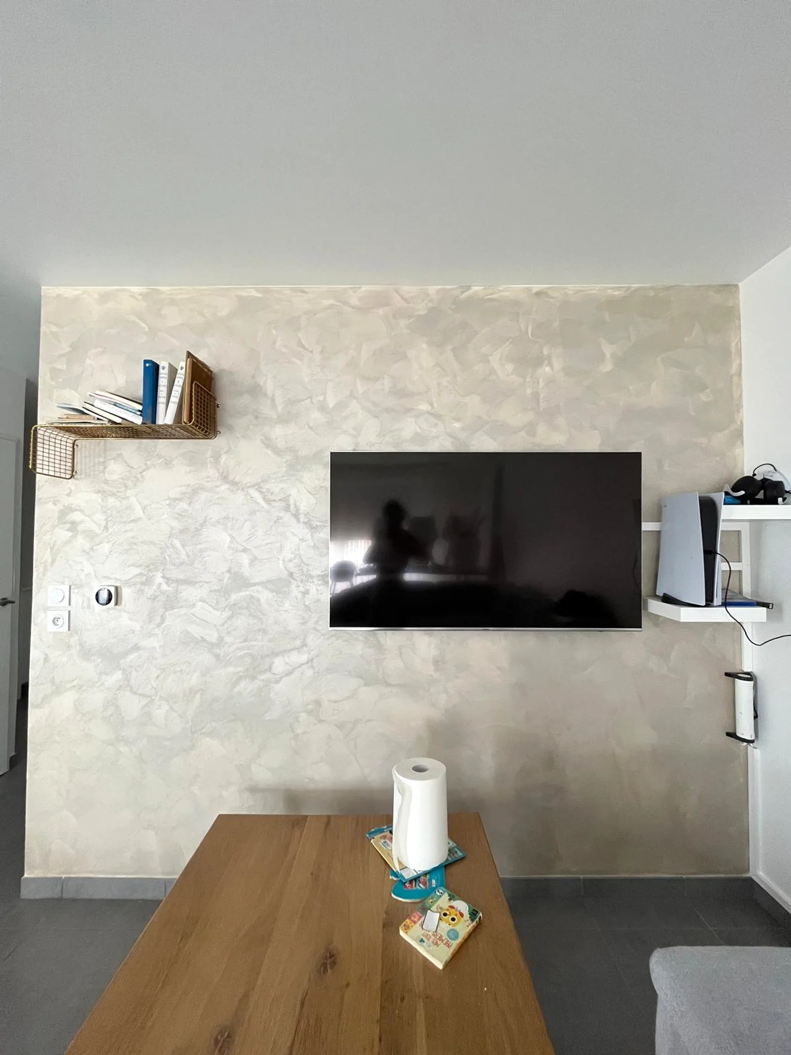 Mur en enduit décoratif nacré réalisé par DOD Peinture derrière un téléviseur.